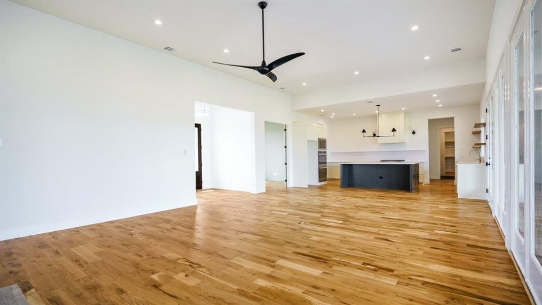 Unfurnished living room featuring light hardwood / wood-style floors, sink, and ceiling fan