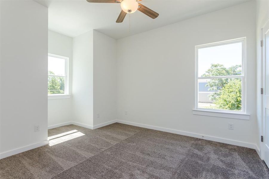 Carpeted empty room with ceiling fan