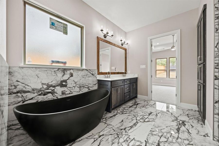 Bathroom with tile patterned floors, vanity, and a bathtub