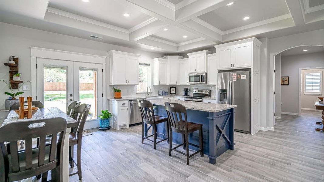 Kitchen featuring light hardwood / wood-style floors, plenty of natural light, stainless steel appliances, and white cabinets