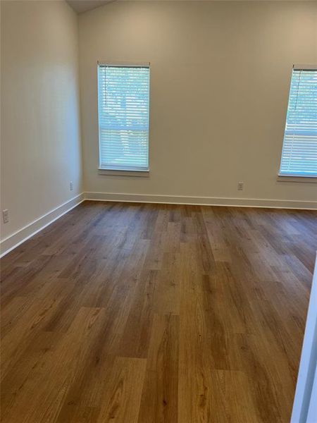 Spare room with dark hardwood / wood-style flooring and lofted ceiling