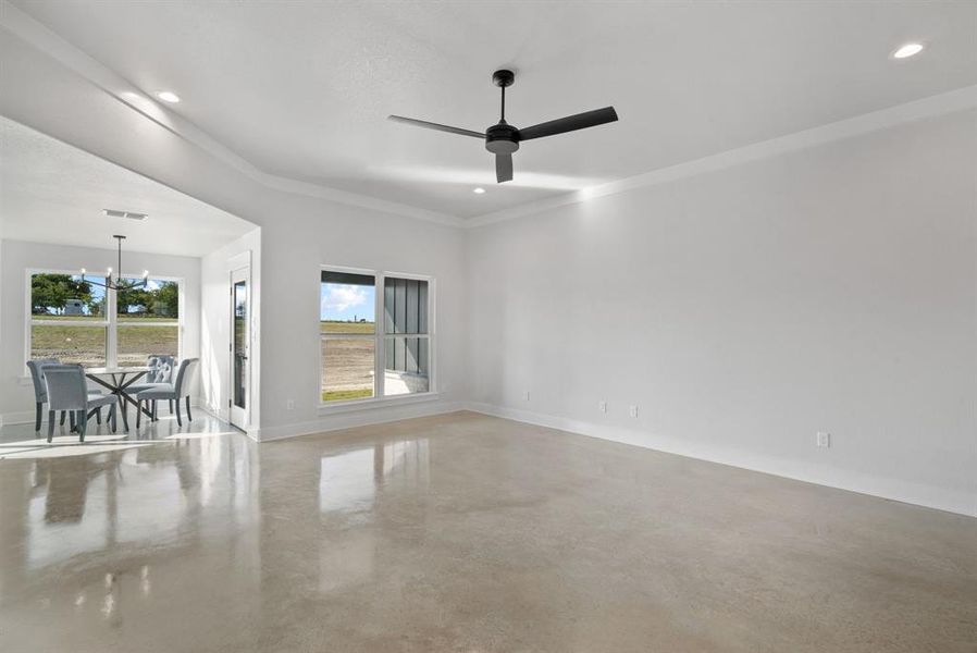 Dining Area / Living room with ornamental molding and ceiling fan with notable chandelier