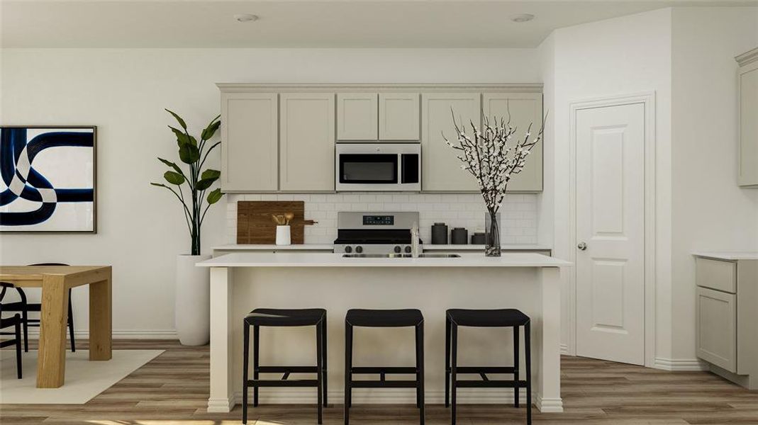 Kitchen with appliances with stainless steel finishes, hardwood / wood-style flooring, backsplash, and a center island with sink