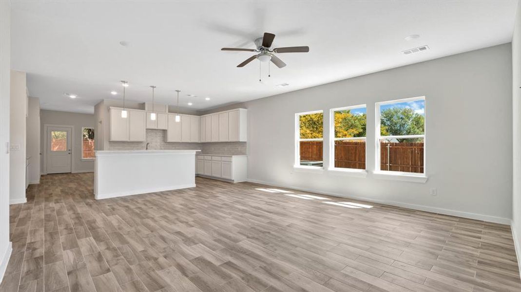 Unfurnished living room with ceiling fan and light wood-type flooring