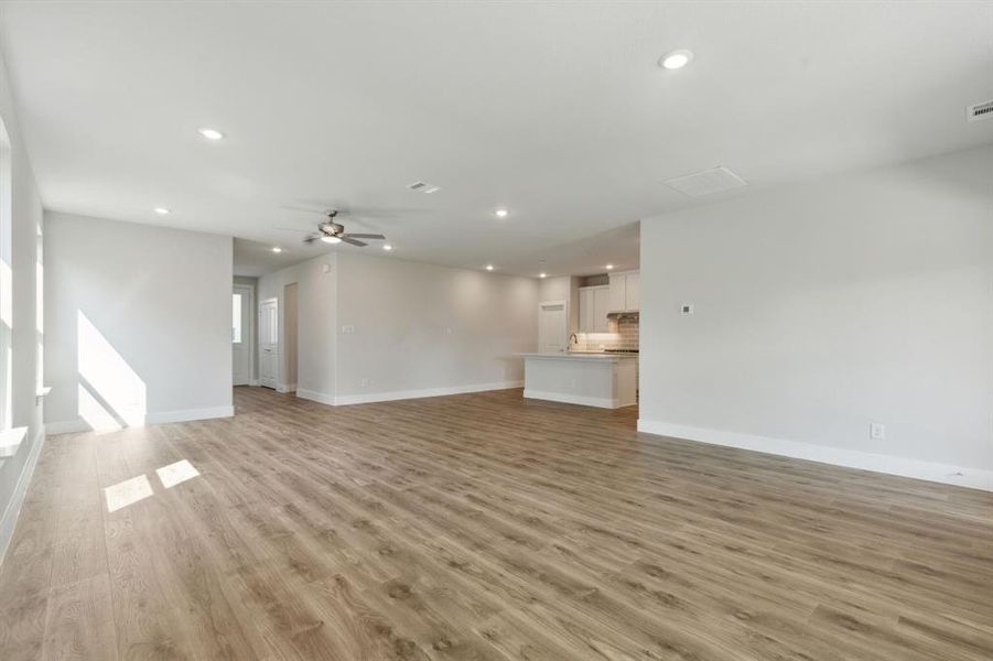 Unfurnished living room with ceiling fan and light hardwood / wood-style floors