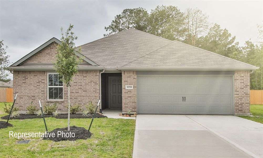 Ranch-style house featuring a front lawn and a garage