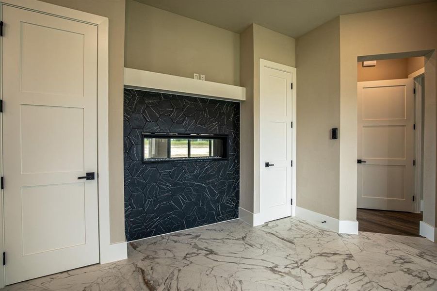 See through gas fireplace between primary bedroom and bathroom