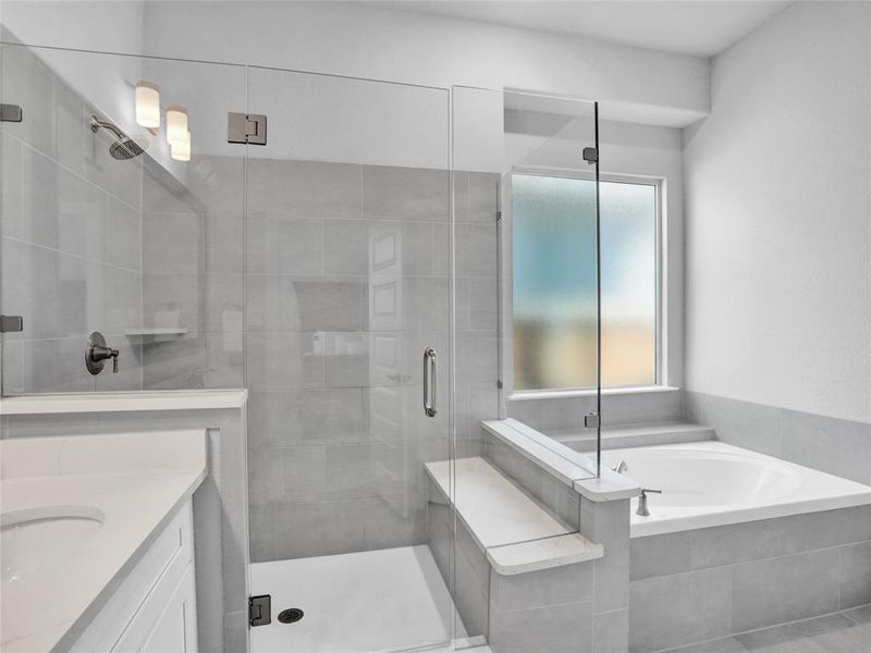 Primary bathroom suite with dual vanities, quartz counters, frameless walk in shower, and garden bath.