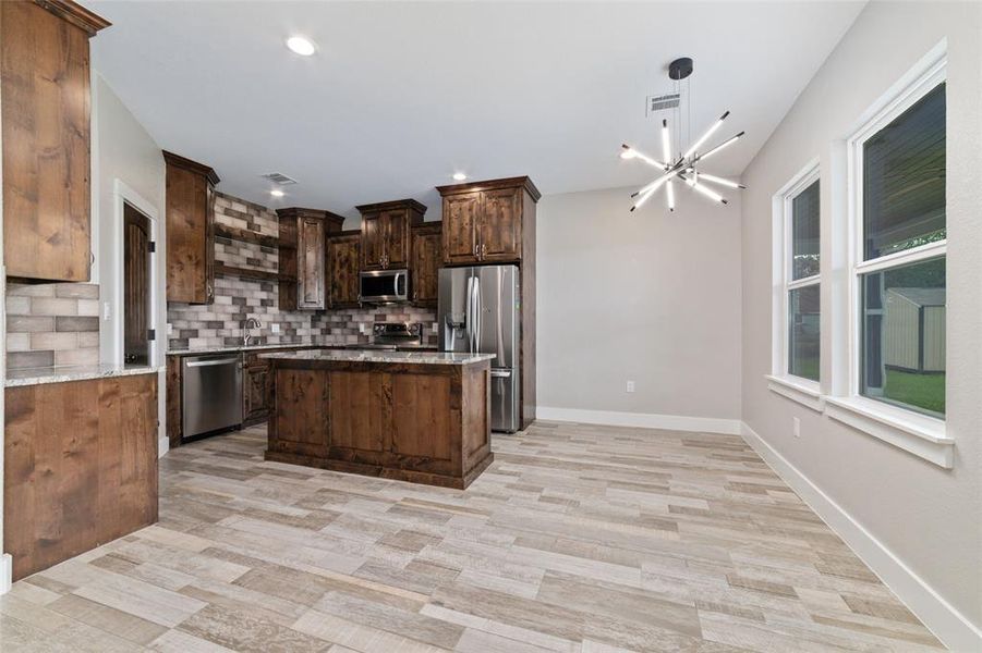 The floating island kitchen is perfect for food preparation or providing extra space as needed. Dark wood cabinetry elegantly accentuates the area, adding a touch of sophistication and functionality to the space.