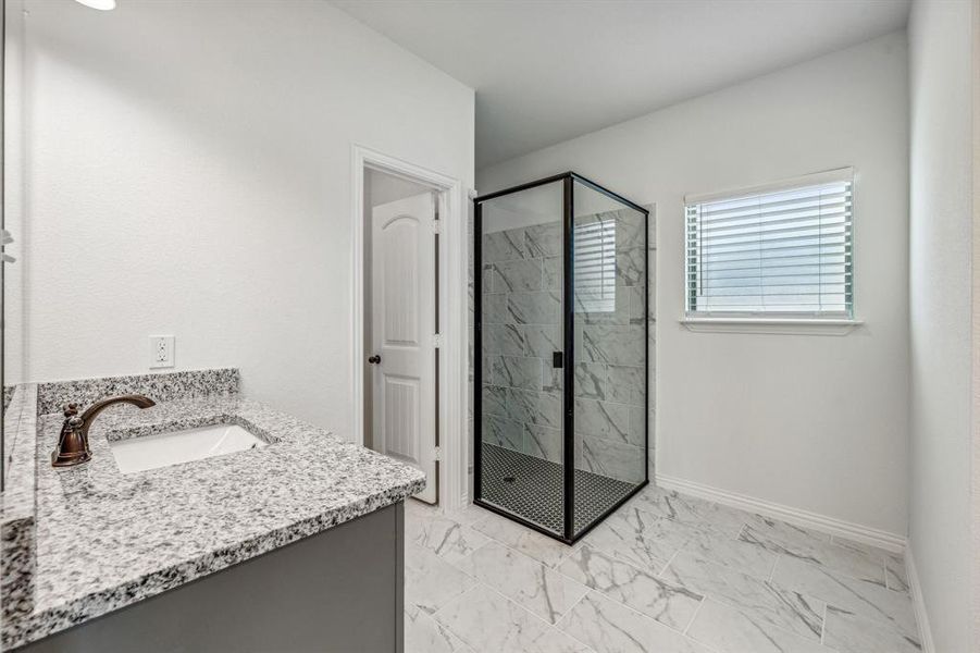 Bathroom with a shower with shower door, vanity, and tile patterned floors