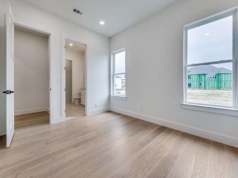 Unfurnished bedroom with light hardwood / wood-style floors and connected bathroom