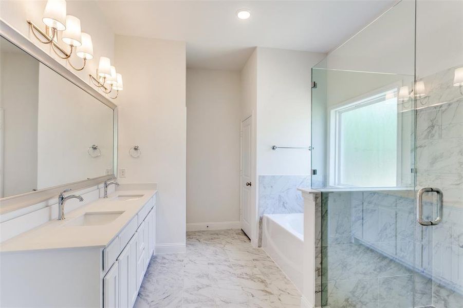 Bathroom with tile flooring, dual vanity, plus walk in shower, and an inviting chandelier