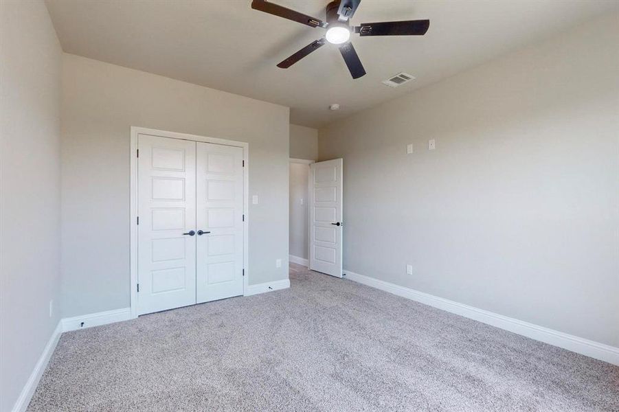 Unfurnished bedroom featuring ceiling fan, a closet, and carpet flooring