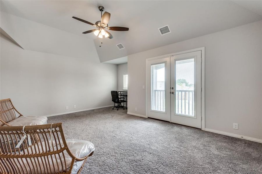 Unfurnished room featuring carpet, vaulted ceiling, ceiling fan, and french doors