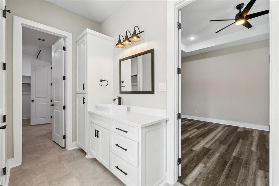 Bathroom with vanity, hardwood / wood-style floors, and ceiling fan