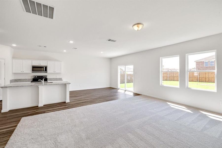 Unfurnished living room with dark wood-type flooring and sink