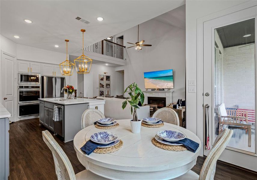 Dining room featuring sink, ceiling fan with notable chandelier, and dark hardwood / wood-style flooring