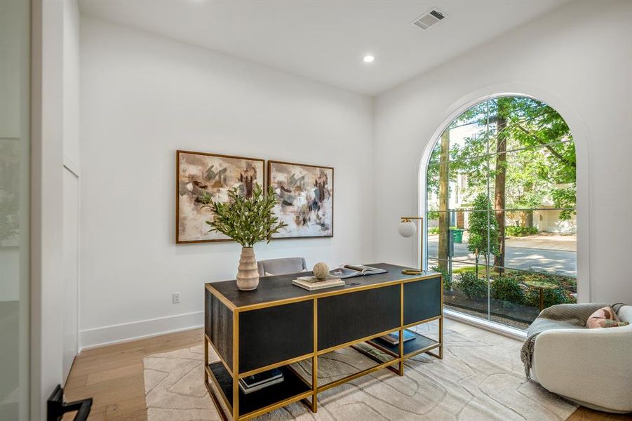 A modern floor-to-ceiling window overlooking the front yard landscaping for ample natural light. This home office/study features in-ground floor outlets for your computer/phone cord needs. Closet to the left for extra storage.