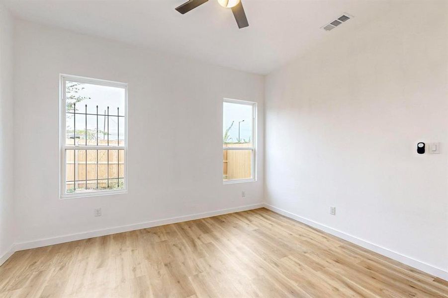 Unfurnished room featuring ceiling fan, light hardwood / wood-style floors, and a healthy amount of sunlight