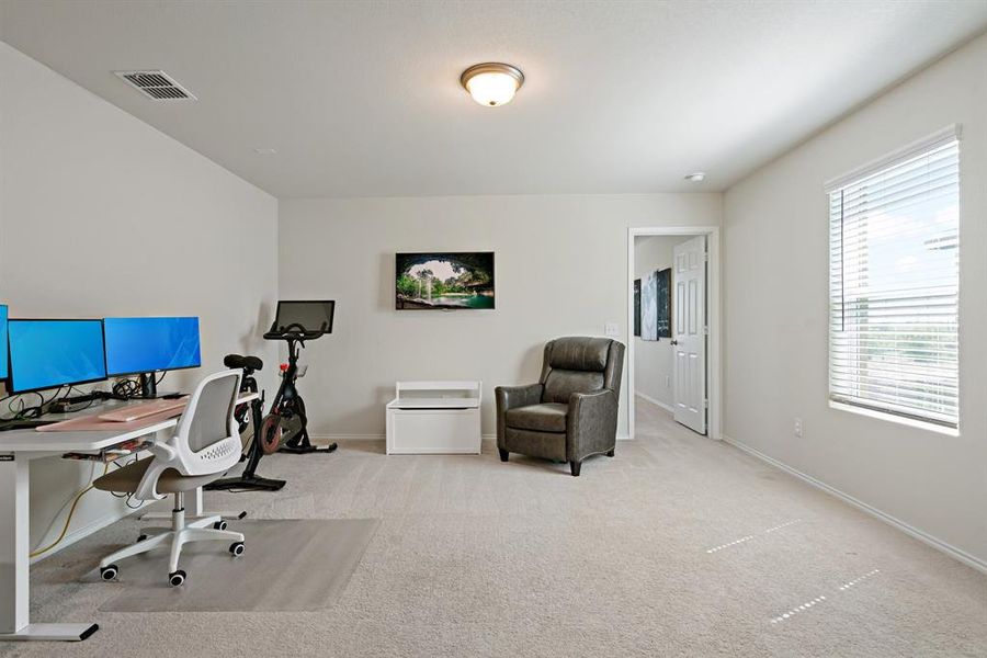 This versatile second-floor living area is perfect for a home office, playroom, or exercise space.