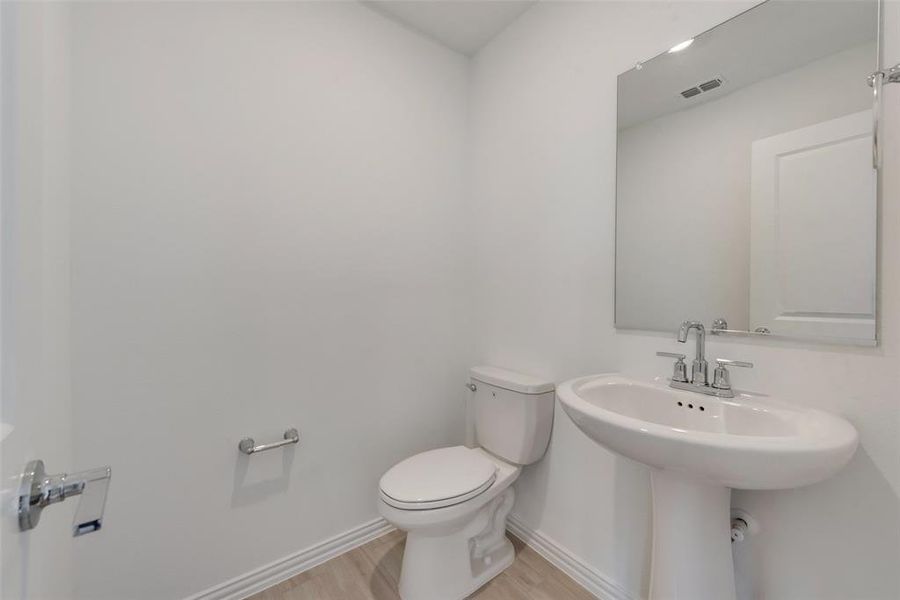 Bathroom with hardwood / wood-style flooring and toilet