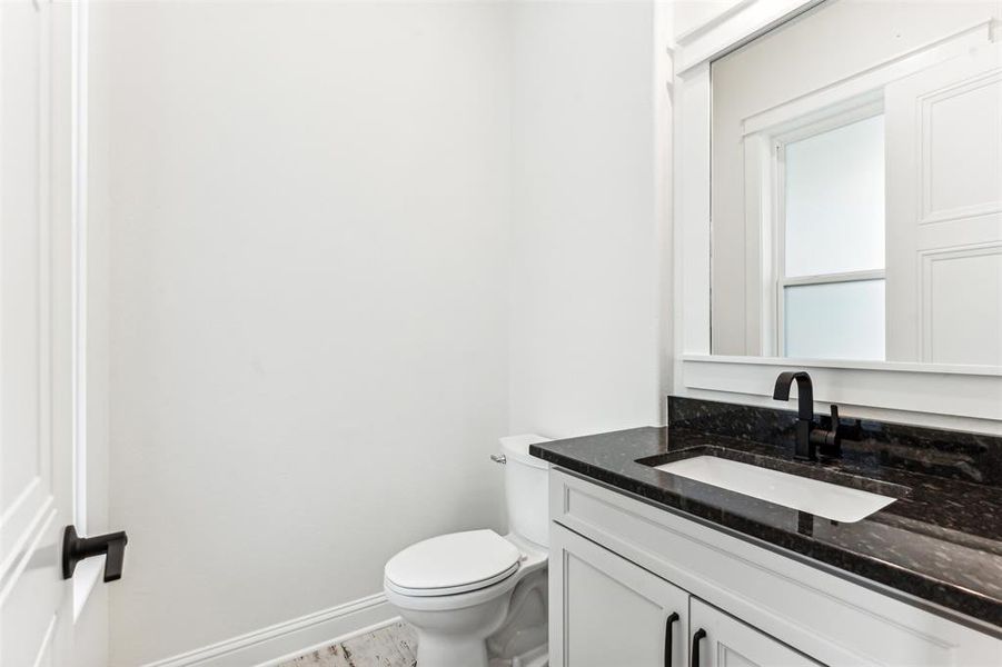 Guest bathroom featuring vanity, toilet, and tile floors