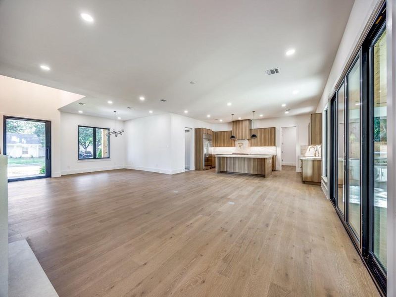 Unfurnished living room with light hardwood / wood-style flooring and an inviting chandelier