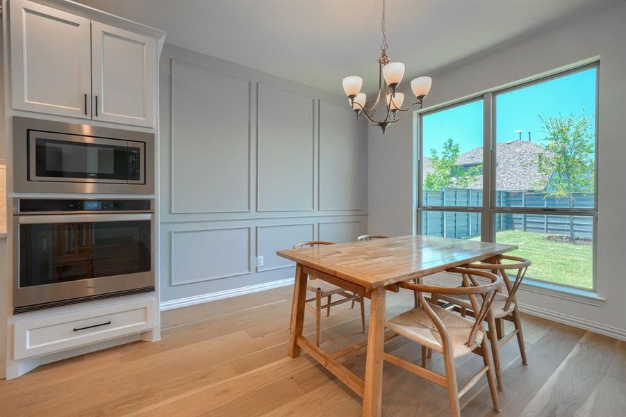 Dining space with a notable chandelier and light wood-type flooring