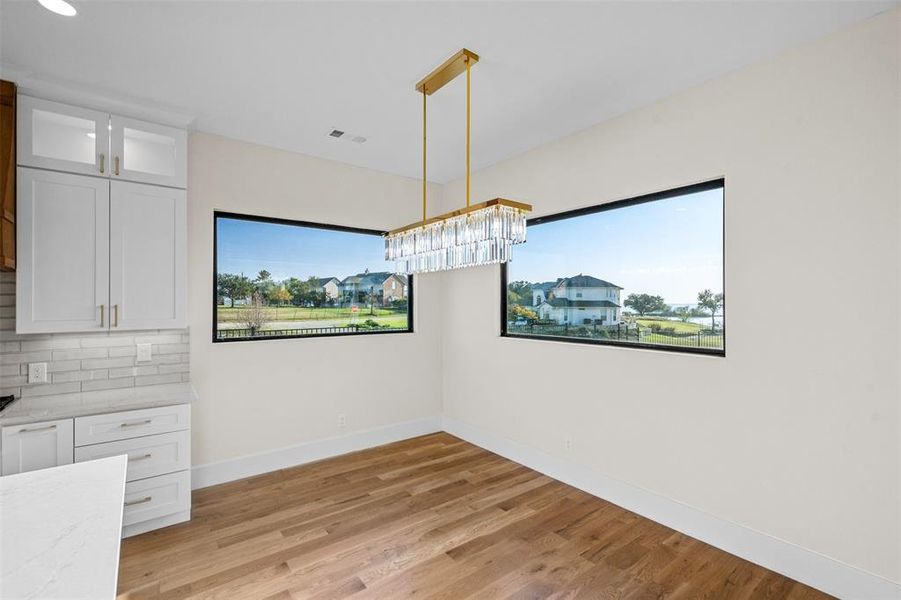 Unfurnished dining area with an inviting chandelier and light hardwood / wood-style floors