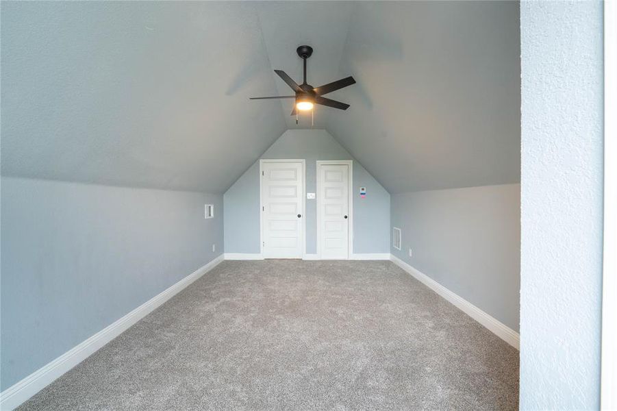 Bonus room with ceiling fan, carpet flooring, and lofted ceiling