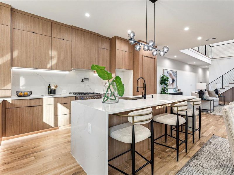 Kitchen featuring pendant lighting, a center island with sink, light hardwood / wood-style flooring, and sink