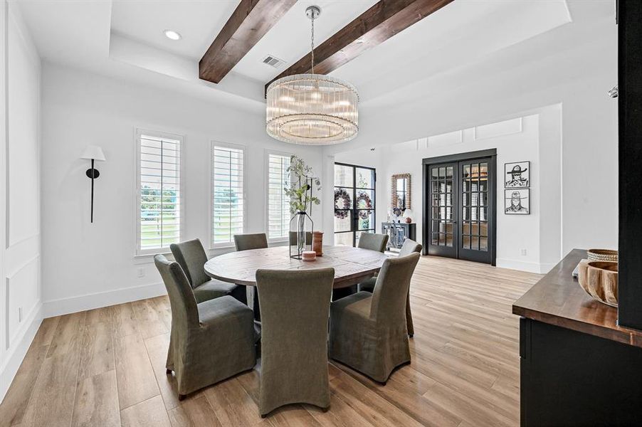 Spacious dining area with elegant exposed beams and abundant natural light.