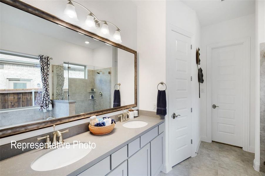 Bathroom with tile flooring, dual vanity, and a shower with shower door