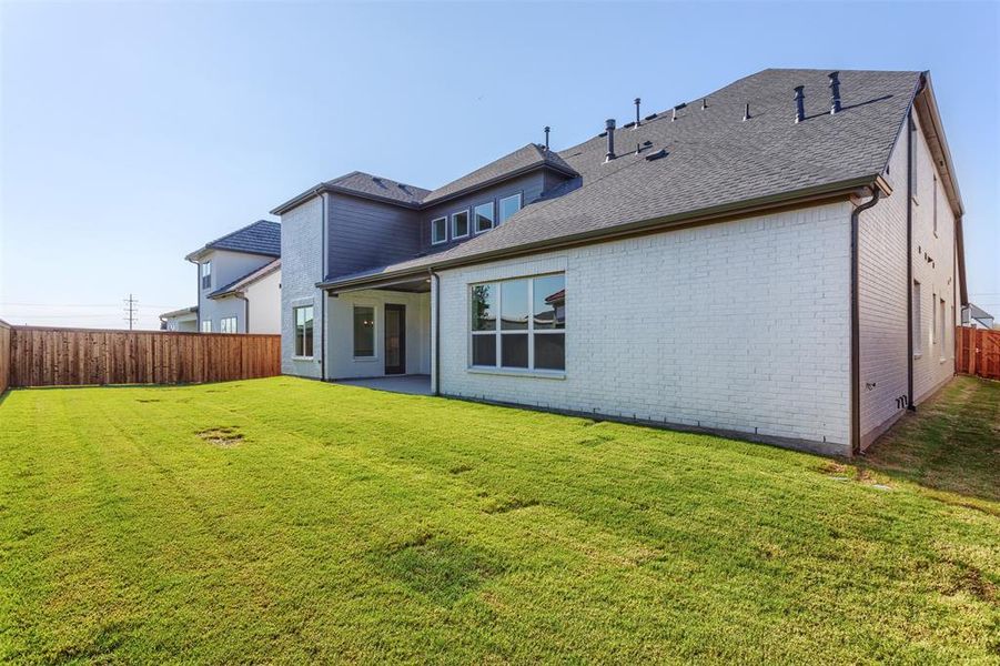 Rear view of house featuring a lawn