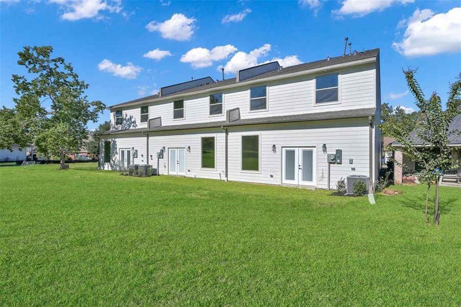 Back of the townhome with green space.