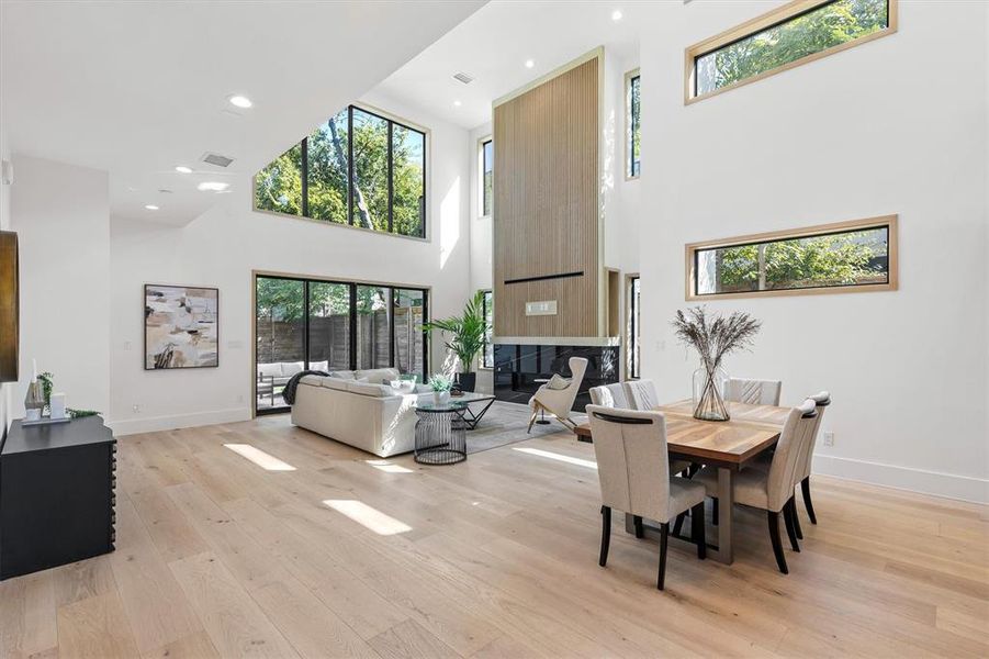 Dining room with a high ceiling and light hardwood / wood-style floors