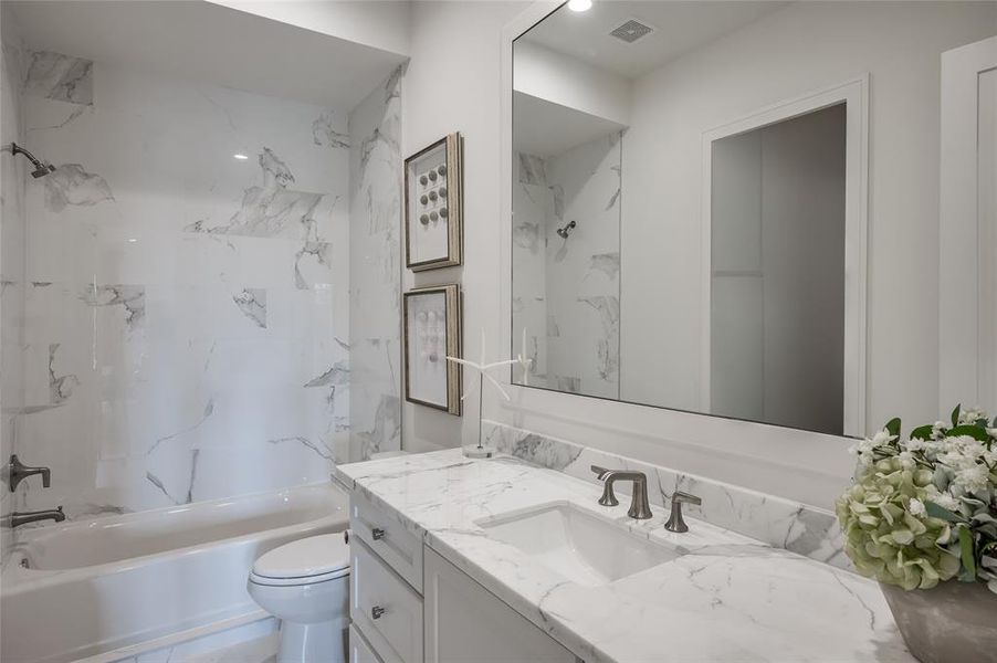 This en-suite bath features marble counters and surround in shower/bath.