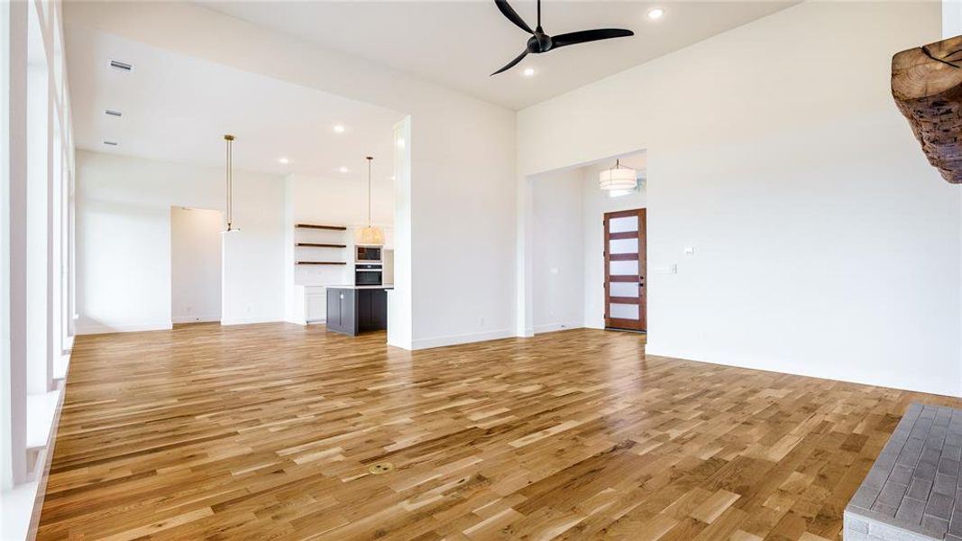 Unfurnished living room with light wood-type flooring and ceiling fan