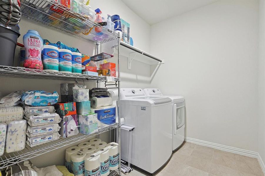 Laundry room with separate washer and dryer and light tile flooring