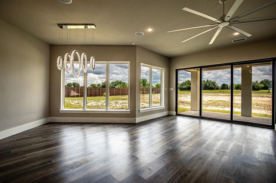 Open concept family room  & dining room with ceiling fan with gorgeous LED chandelier