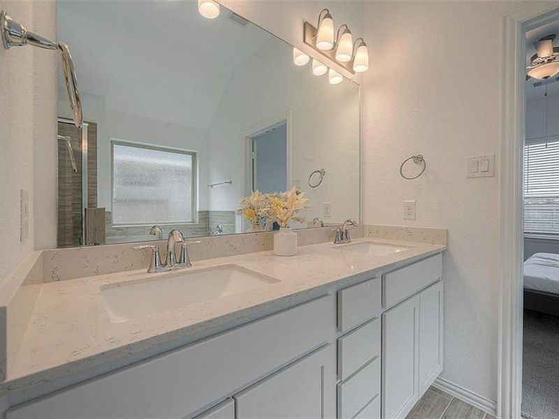 The clean lines of the double vanity and the large mirror above it contribute to an uncluttered and organized feel in this bathroom.