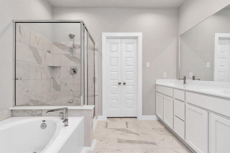 The primary en-suite has a soaking tub to give you that spa experience. The large privacy window allow lots of nature light in the space. Sample photo of completed home with similar floor plan. As-built interior colors and selections may vary.