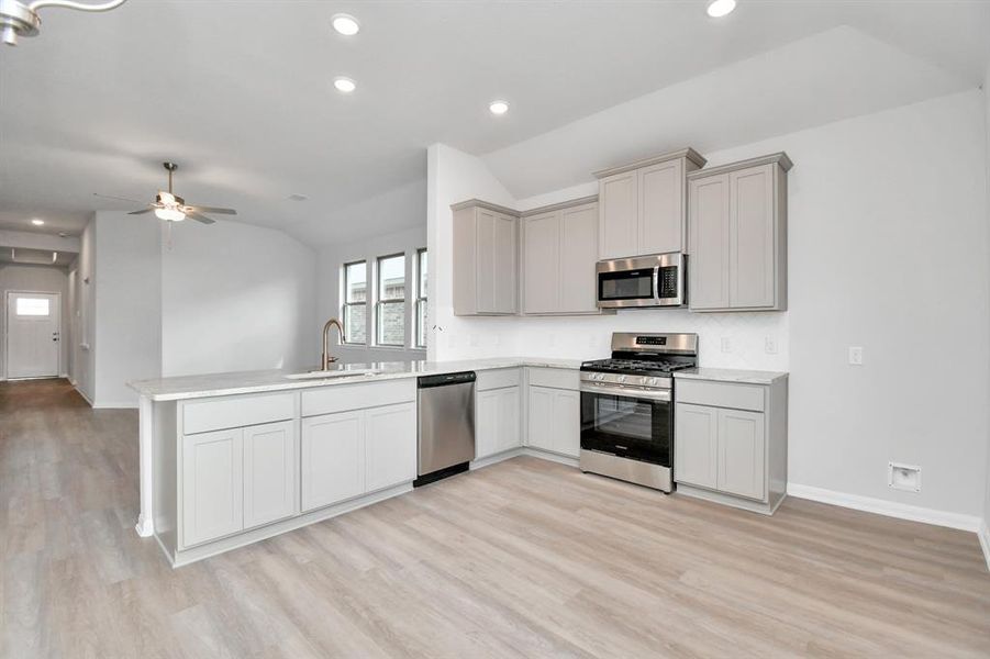 The kitchen also boasts a large sink with a modern, gold-toned faucet, enhancing the elegant aesthetic.