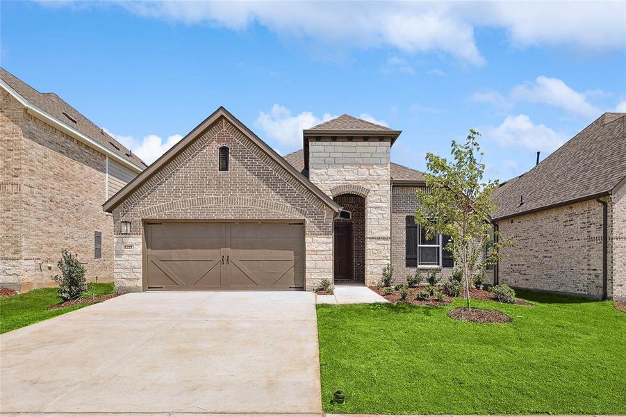 French provincial home featuring a front lawn and a garage