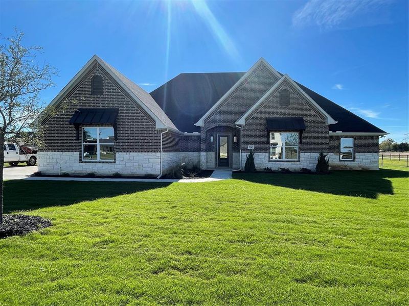 French country home featuring a front yard