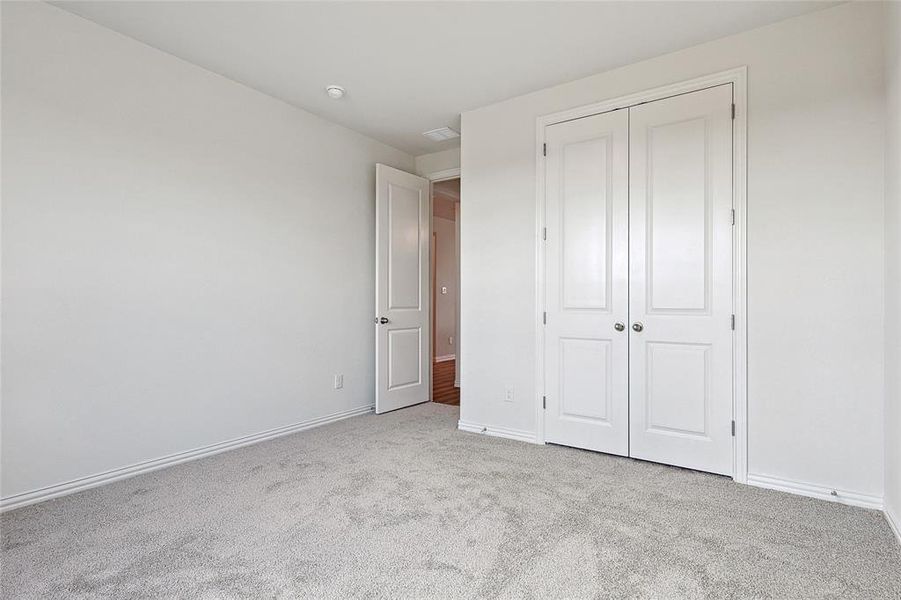 Unfurnished bedroom with a closet and light colored carpet