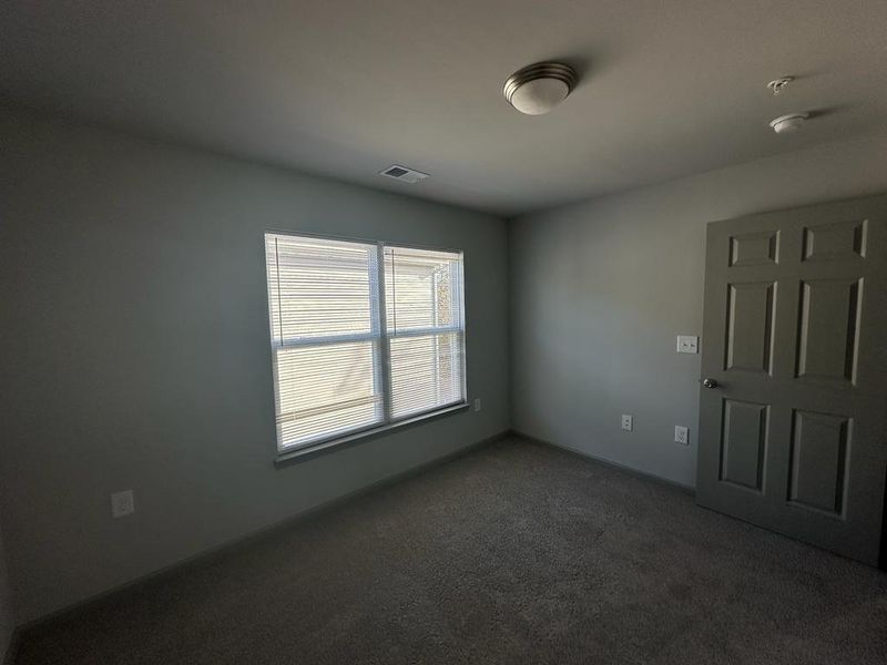 Unfurnished room featuring dark carpet