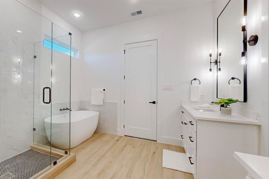 Bathroom featuring hardwood / wood-style floors, vanity, and independent shower and bath