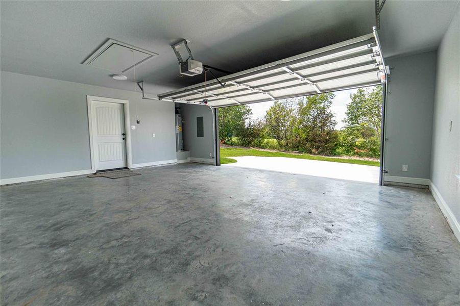 Garage featuring a garage door opener and water heater