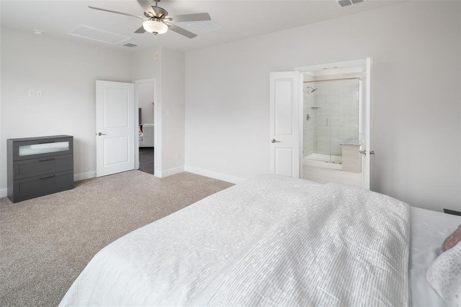 Bedroom featuring ensuite bathroom, ceiling fan, and carpet